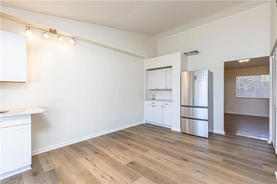Kitchen featuring white cabinets, lofted ceiling, 