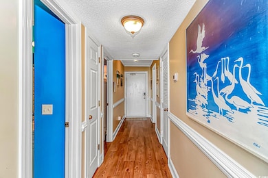 Corridor featuring a textured ceiling and wood fin
