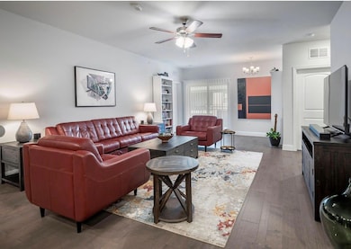 Living room featuring ceiling fan with notable cha