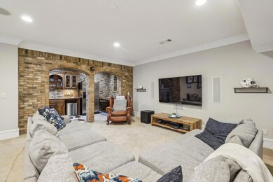 The Fully Finished Daylight Terrace Level is made for Entertaining with a Large Living Space, Built-In Sound System, Wet Bar framed by Brick Archways, and Direct Access to a Charming Outdoor Patio.