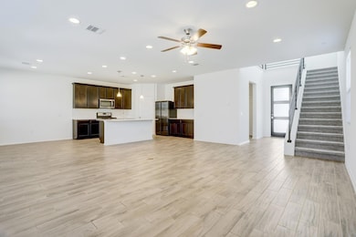 Unfurnished living room featuring stairway, recessed lighting, ceiling fan, and light wood-style floors