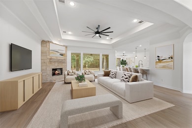 The corner fireplace anchors the living room with tray ceiling, recessed lighting and views to the backyard. Virtually staged