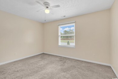 Empty room featuring carpet, a textured ceiling, a