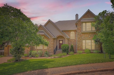 Tudor house with brick siding, a front yard, a ch