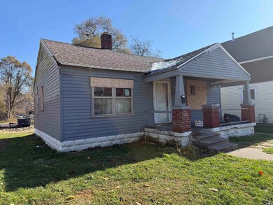 Bungalow-style house featuring a front lawn, covered porch, a chimney, and roof with shingles
