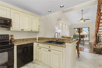 Kitchen with cream cabinets, black appliances, sin