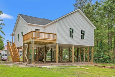 Back of property with a carport, stairs, roof with shingles, and a deck