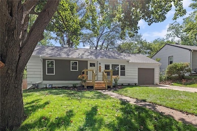 Ranch-style home featuring a front yard, a shingled roof, an attached garage, and concrete driveway