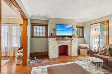 Living room featuring a brick fireplace and wood-type flooring