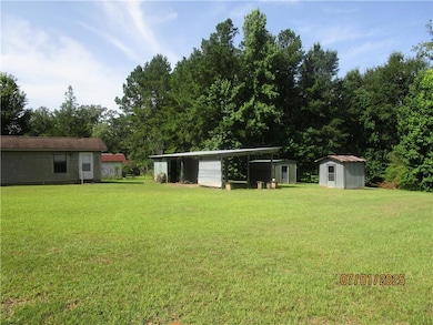 Carport, storage shed and Greenhouse behind
