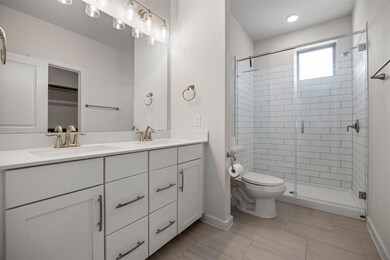 Bathroom featuring double vanity, a shower stall,