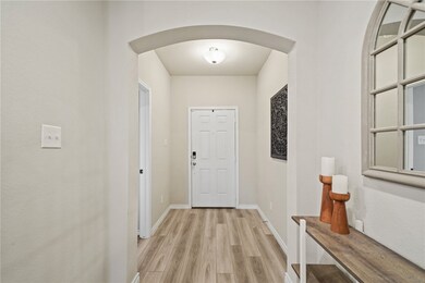Doorway to outside featuring arched walkways, ligh