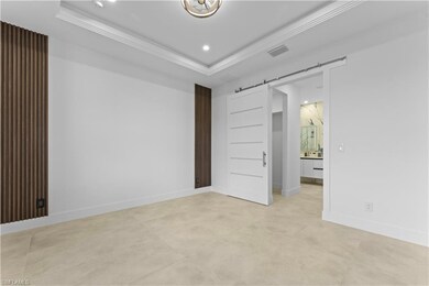 Primary room with ornamental molding, a tray ceili