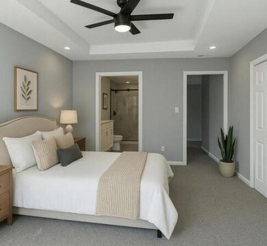 Bedroom featuring a raised ceiling, baseboards, en
