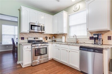 Beautiful Bright kitchen with Granite counter tops and tile backsplash.