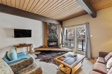 Carpeted living room featuring a fireplace, a wooden ceiling with exposed beams, and baseboard heating