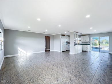 Unfurnished living room featuring crown molding, r