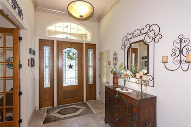 Entrance foyer with crown molding, light tile pat