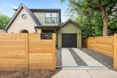 View of front of house with a gate, fence, a gara