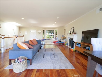 View from the balcony into the living room with bay window overlooking private front patio