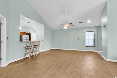 Living room with light wood-type flooring, vaulted ceiling, and ceiling fan