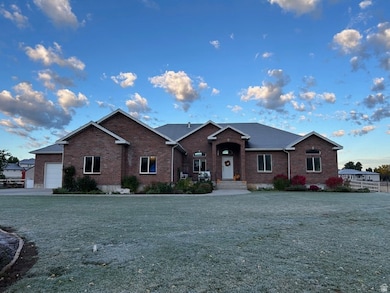 Ranch-style house featuring brick siding, a front lawn, and an attached garage