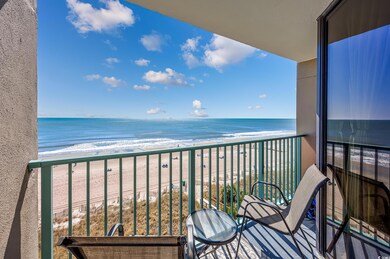 Balcony featuring view of water and beach