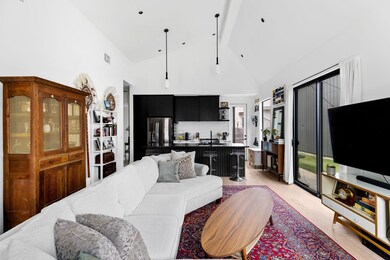 Living area featuring high vaulted ceiling, light