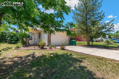 View of front of house with a garage, concrete driveway, and a front yard