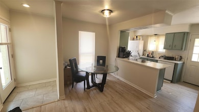 Kitchen with stacked washer / dryer, light counte