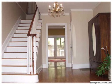 Lovely foyer with wood stairway and a coat closet
