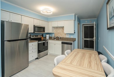 Kitchen with white cabinetry, stainless steel appl