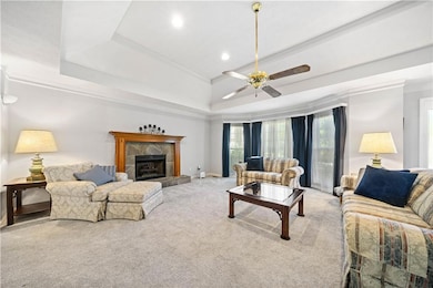 Carpeted living room with baseboards, ornamental m