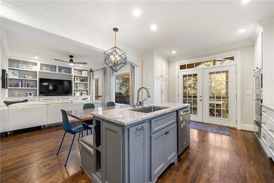 Kitchen featuring light stone counters, hanging li