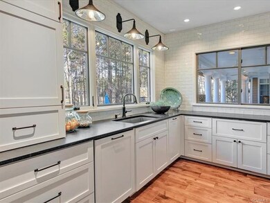 Another view of the kitchen with  showing a large picture window overlooking the pool & golf course. The side window is a pass thru to the covered patio. Great for entertaining.