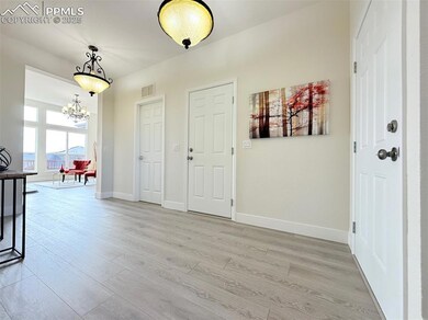 Foyer entrance with light wood-type flooring and a chandelier