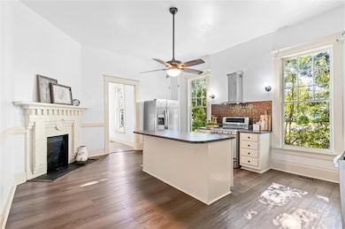 Unfurnished living room featuring ceiling fan, dar