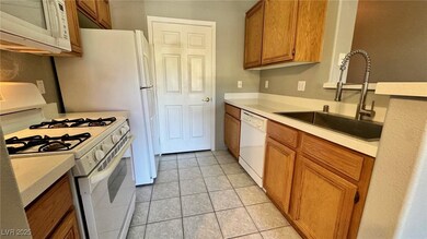 Kitchen with white appliances, brown cabinets, lig
