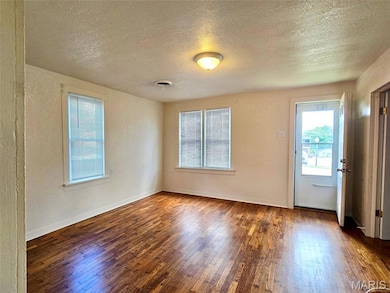 Foyer with a textured ceiling and dark wood-type flooring