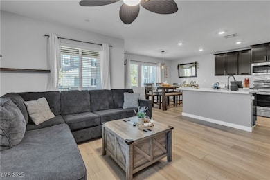 Living area with light wood-style flooring, recessed lighting, and ceiling fan