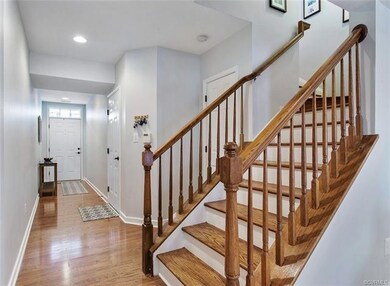 Bright entry hall with hardwood floor, recessed li