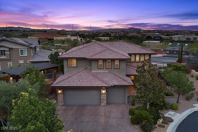 View of front facade featuring stucco siding, driveway, a tiled roof, a garage, and a residential view