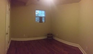 Spare room featuring wood finished floors and baseboards