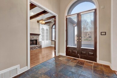Tiled entrance foyer featuring a notable chandelie