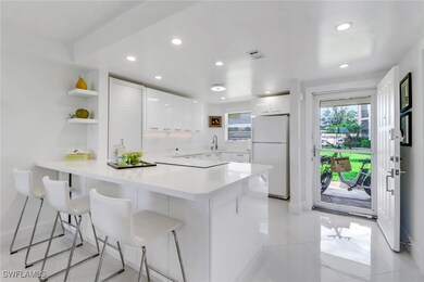 Kitchen featuring freestanding refrigerator, a sin