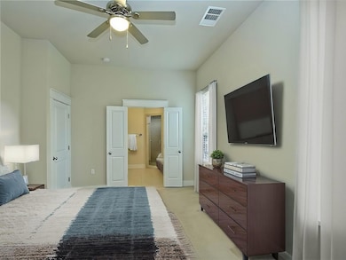 Bedroom with ensuite bath, baseboards, light colo