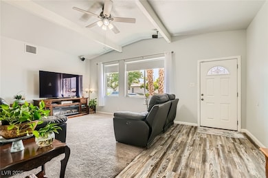 Living area featuring a ceiling fan, wood finished
