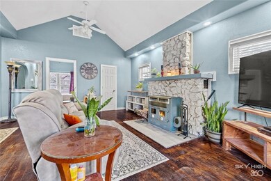 The main living area with vaulted ceiling, recessed lighting, and native Arkansas stone fireplace complete with wood-burning stove.