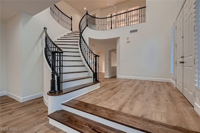 Foyer entrance with a chandelier, wood finished fl