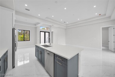 Kitchen featuring a sink, an island with sink, a t